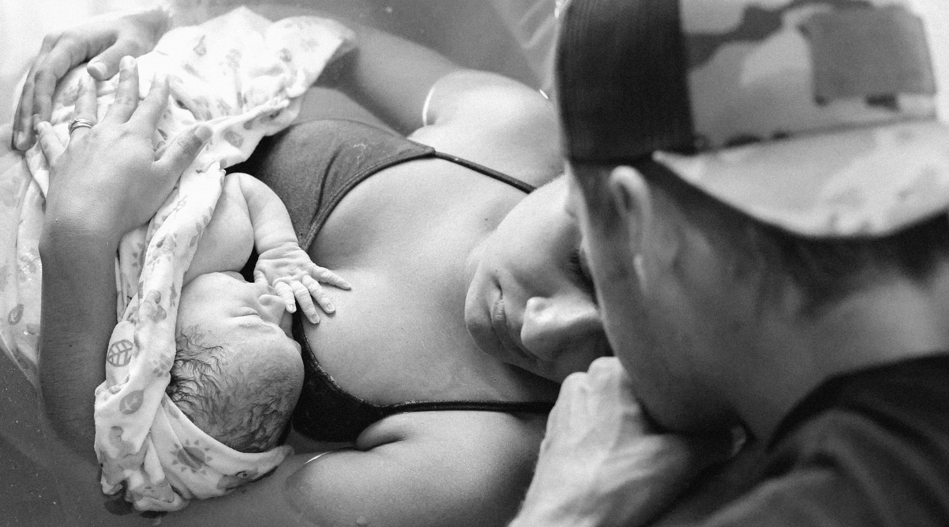 A mother and father gaze at their newborn.