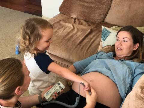 An older sibling helps Karen use the Doppler to check baby's heartbeat.