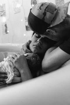 New parents hold their baby and get a chance to rest after the birth.